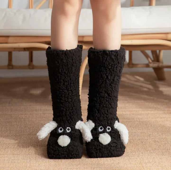 Black fuzzy slippers with cartoon face design worn indoors.