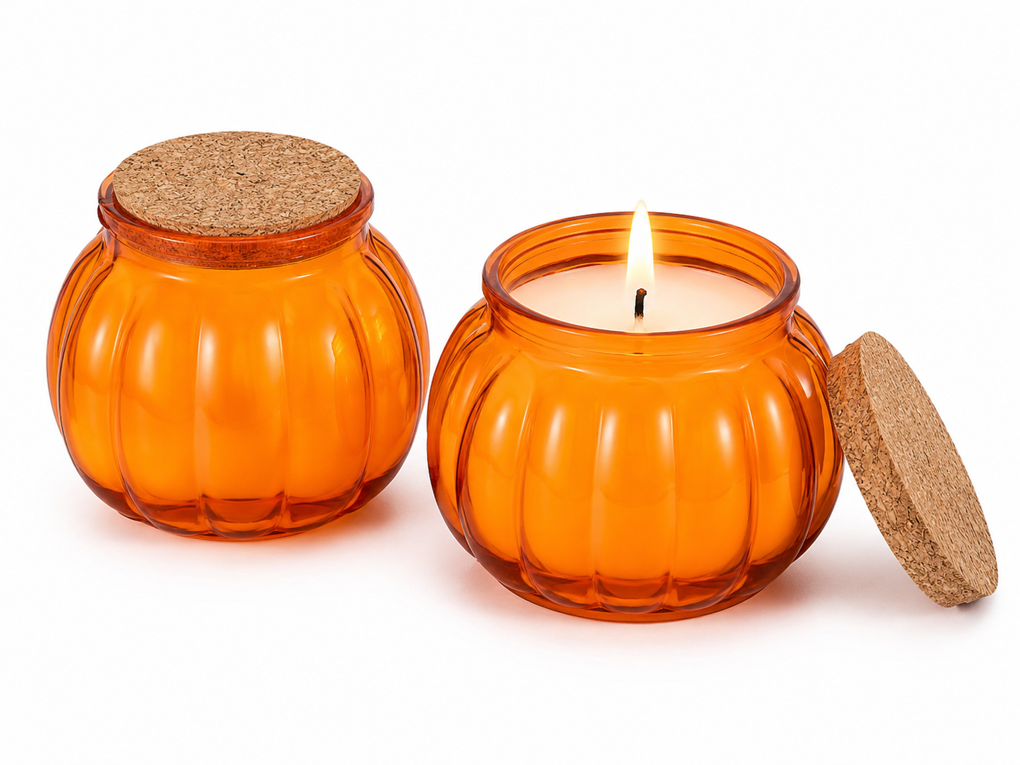 An orange pumpkin-shaped glass candle jar with a cork lid, shown both closed and open with a lit candle on a white background.